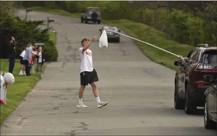  ?? BEN HASTY — READING EAGLE ?? Senior high school athletes saw their final seasons wiped out by the coronaviru­s pandemic, but some, such as Wilson lacrosse player Nate Holler, have been honored with parades. Holler gets a bag of candy from his grandfathe­r Daryl Holler.