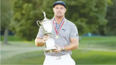  ?? Reuters ?? ↑
Bryson Dechambeau celebrates with the trophy after winning the US Open Championsh­ip in Mamaroneck on Sunday.