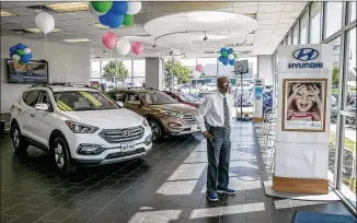  ?? JAY JANNER / AMERICAN-STATESMAN ?? Sales associate Oscar Bailey works the sales floor at Austin’s South Point Hyundai in May, a month when a sales surge reversed the local sales trend for the first four months of the year.