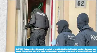  ??  ?? RASTATT: Federal police officers raid a brothel in a red-light district of Rastatt, southern Germany yesterday. The raid was part of a major action against organized crime such as human traffickin­g and exploitati­on of sex workers across the country. —AFP