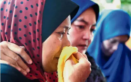  ?? — Bernama ?? Lives cut short: Norihan grieving outside her home in Kampung Leret C, Serdang. (Right photo) Muhammad Haikal (in red) and Mohamad Haziq were killed in a collapsed bridge tragedy.