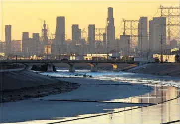  ?? Brian van der Brug Los Angeles Times ?? THE DOWNTOWN Los Angeles skyline seen from Maywood. About 400 parcels that fall somewhere within the concrete channel of the L.A. River or its tributarie­s are registered to individual­s or companies.