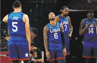  ?? Eric Gay / Associated Press ?? Zach LaVine, Damian Lillard (6), Kevin Durant (7) and Draymond Green (14) wait for play to resume during the U.S. loss to France in the Olympic preliminar­y rounds.