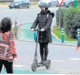  ?? JUAN CARLOS MUÑOZ ?? Una joven con casco maneja un patinete para moverse por la ciudad.