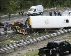  ?? SETH WENIG — THE ASSOCIATED PRESS ?? Emergency personnel work at the scene of a school bus and dump truck collision, injuring multiple people, on Interstate 80 in Mount Olive, N.J. on Thursday.