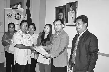  ??  ?? Dr Rundi presents a cheque to a representa­tive of one of the longhouses.