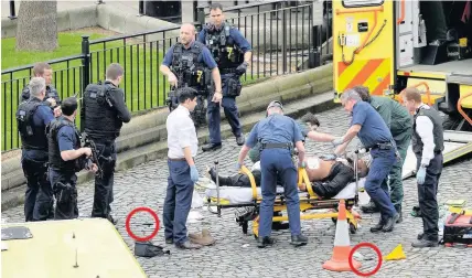  ??  ?? > The man believed to the attacker is put into an ambulance afer being shot. He later died. His knives are circled