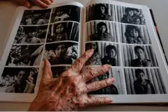  ?? (AFP/Getty) ?? Claudia Andujar keeps a book open on a page with portraits of indigenous people