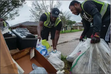  ?? (AP/The Times-Picayune/The New Orleans Advocate/Chris Granger) ?? Elmor Garcia and Bruce Hayes (left) of IV Waste pick up trash and storm debris from Hurricane Ida in Kenner, La.