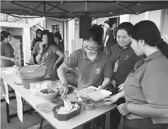  ??  ?? Business administra­tion students busy preparing food for sale.