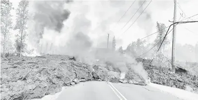  ?? — Gambar Reuters ?? MENGGERUNK­AN: Lahar panas mengalir di sepanjang jalan dekat satu retakan di Estet Leilani di baagian East Rift Zone, Hawaii kelmarin.