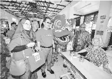  ??  ?? Azlan MdAlifiah (centre) and Datuk Dr Khalid Ibrahim (in batik) with one of the occupants at the National Leprosy Control Centre. Bernama photo