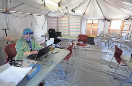  ?? SETH HARRISON/USA TODAY NETWORK ?? Cathy Hopkins inputs patient data in what was sometimes a standing-room-only intake tent outside St. Joseph Medical Center on April 22 in Yonkers, N.Y.