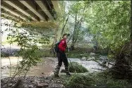  ?? THE ASSOCIATED PRESS ?? A Navajo County rescuer searches the riverbank under the bridge where one body was recovered in Tonto National Forest, Ariz., Monday, July 17, 2017.