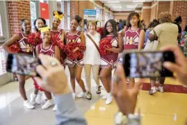  ?? STAFF PHOTO BY DOUG STRICKLAND ?? Hamilton County Schools board member Kathy Lennon, center, takes a photo Tuesday with Howard cheerleade­rs during the Opportunit­y Zone Community Celebratio­n Phase II at Howard School. Parents, school faculty and community members gathered to note the accomplish­ments of the Opportunit­y Zone schools.