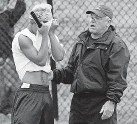  ?? ARCHIVES] [OKLAHOMAN ?? Larry Latimer, a longtime high school coach, comforts a track athlete during the 2006 state meet. Latimer coached football the last two seasons at Konawa High School.