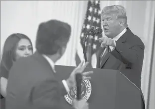  ?? OLIVER CONTRERAS | TNS ?? A WHITE HOUSE staff member, left, tries to take away the microphone from CNN White House correspond­ent Jim Acosta during an exchange with President Donald Trump on Nov. 7.