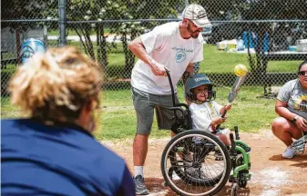  ?? Photos by Brett Coomer / Staff photograph­er ?? Nalah Best, 10, cracks the ball with her father, Michael, at the softball event, which benefited her nonprofit. “We’re bringing the community together and really helping them understand that there is a need for this because so many people with different abilities, they have things they want to do, and there’s just not always an outlet for them,” said her mom, Ericka-Michelle Best.
