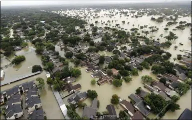  ?? DAVID J. PHILLIP — ASSOCIATED PRESS ?? Homes in a Houston neighborho­od are shown amid rising floodwater­s on Tuesday.