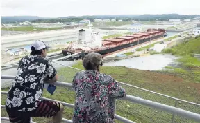  ??  ?? Tourists watch a Malta-flagged cargo ship pass through the Panama Canal in Agua Clara, Panama, on Friday, June 10, 2016. Panama is among several regional countries contributi­ng to growth in shipment volumes in 2017.