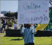  ?? PHOTO BY ANNE WERNIKOFF, CALMATTERS ?? TK student Jake Schuman, 5, holds up a sign during a rally to reopen schools at Astro Park in Oakland on Feb. 28.