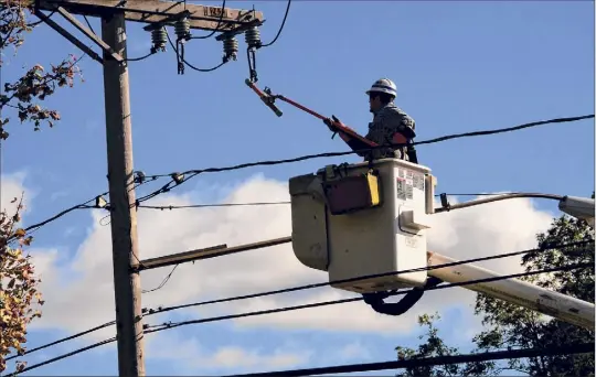  ?? Lori Van Buren / Times Union ?? A National Grid lineman is seen working on a power line along Western Ave. in front of Hannaford on Oct. 8 in Guilderlan­d. Electric substation­s sometimes cause controvers­y, but they are making it easier for solar farm developers to site projects upstate and in the Capital Region.