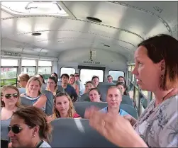  ?? CLAIRE BESSETTE/THE DAY ?? Heidi Davis, new principal of the Samuel Huntington School, tells a bus full of fellow new Norwich school system employees Monday about her historic school that opened in the 1920s with separate entrances for boys and girls.