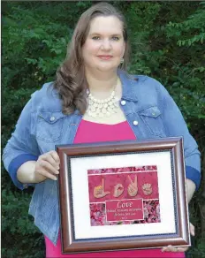  ?? Special to the Democrat-Gazette ?? Bentonvill­e artist Connie Rowland holds her work “Love One Another.” The piece is one of many from her Master’s Hand Collection, inspired by the idea to feature literal hands as a metaphor for realizing God’s hand at work in one’s life.