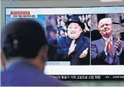  ?? [AP PHOTO] ?? A man watches a TV screen showing file footage of U.S. President Donald Trump, right, and North Korean leader Kim Jong Un, left, during a news program Wednesday at the Seoul Railway Station in Seoul, South Korea.