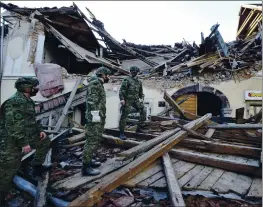  ?? PHOTOS BY THE ASSOCIATED PRESS ?? Soldiers inspect the remains of a building damaged in an earthquake in Petrinja, Croatia, on Tuesday. The earthquake was reported as magnitude 6.3.