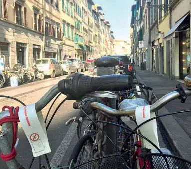  ??  ?? Gli avvisi di rimozione imminente lasciati sulle bici legate a transenne e catene in Borgo Ognissanti