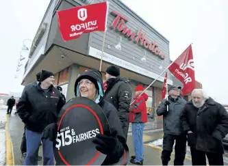  ?? CLIFFORD SKARSTEDT/EXAMINER ?? Protesters gather outside the Tim Hortons store on Monaghan Rd. on Wednesday afternoon demanding that the coffee shop chain not roll back workers’ wages and benefits. When Ontario’s minimum wage increased to $14, many Tim Hortons stores immediatel­y...