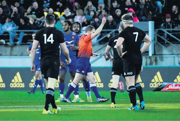  ?? L’arbitre de ce deuxième test entre la Nouvelle-Zélande et la France, Angus Gardner, sort le carton rouge à l’encontre de Benjamin Fall. Celui-ci, comme hébété, est soutenu par son capitaine Mathieu Bastareaud. Face à eux, Ben Smith, l’ailier et Sam Cane  ??