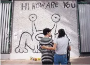  ?? NICK WAGNER/ASSOCIATED PRESS ?? Lydia Moore and her son, Ethan, pay their respects at a mural created by Daniel Johnston in Austin, Texas. The quirky singer-songwriter and visual artist died Sept. 11.
