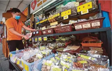  ?? PIC BY ASWADI ALIAS ?? A traditiona­l Chinese medicine trader arranging herbal products outside his shop in Pasar Lido Square, Kota Kinabalu, recently.