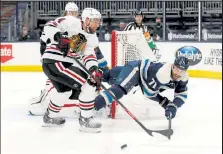  ?? Kirk Irwin / Getty Images ?? Blue Jackets forward Nick Foligno, right, loses his footing while battling for control of the puck with Blackhawks defenseman Calvin de Haan during Tuesday’s game at Nationwide Arena in Columbus, Ohio.