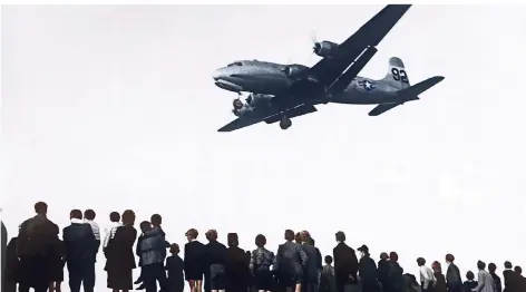  ?? FOTO: DPA ?? Berliner verfolgen im Mai 1949 die Landung einer US-Militärmas­chine auf dem Flughafen Tempelhof während der Luftblocka­de durch die Sowjets.