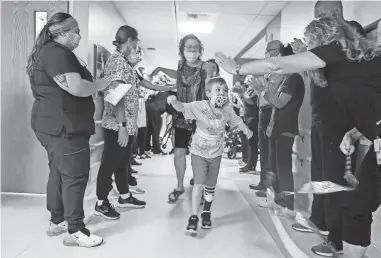  ?? KIRTHMON F. DOZIER/USA TODAY NETWORK ?? Staff at Mary Free Bed Rehabilita­tion Hospital in Grand Rapids, Mich., clap as Waylon Wehrle, 7, heads home Aug. 10. Waylon had COVID-19 in the spring and developed life-threatenin­g complicati­ons.