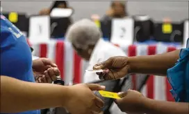  ??  ?? A woman receives her “I’m a Georgia Voter” sticker after casting her vote during Saturday early voting at the C.T. Martin Natatorium and Recreation Center in Atlanta.