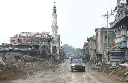  ?? PRESIDENTI­AL FILE FOTO ?? RUINED. In this file photo, President Rodrigo Duterte surveys the devastatio­n wrought by the war with Maute militants inspired by global terror group Islamic State in Marawi City in Lanao del Sur.