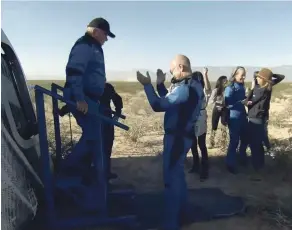  ?? BLUE ORIGIN VIA ASSOCIATED PRESS ?? William Shatner exits the Blue Origin capsule Wednesday as he is greeted by Jeff Bezos near Van Horn, Texas. The Star Trek actor and three fellow passengers hurtled to an altitude of 66.5 miles over the West Texas desert in the fully automated capsule, then safely parachuted back to Earth in a flight that lasted just over 10 minutes.