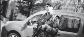  ?? AP/KAMIL ZIHNIOGLU ?? A French soldier stands near the scene where French soldiers were hit and injured by a vehicle Wednesday in the western Paris suburb of Levallois-Perret near Paris.