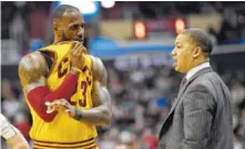  ??  ?? Cleveland Cavaliers forward LeBron James talks with Cleveland Cavaliers head coach Tyronn Lue, right, during the first half of a game against the Washington Wizards in Washington. Lue would prefer less attention, but it comes with the territory as...