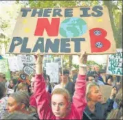  ?? REUTERS ?? ■ LONDON: People hold placards at a climate change march.