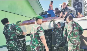  ?? — AFP photo ?? Indonesian soldiers prepare coffins for constructi­on workers, believed to have been shot dead, in Wamena in Papua province.