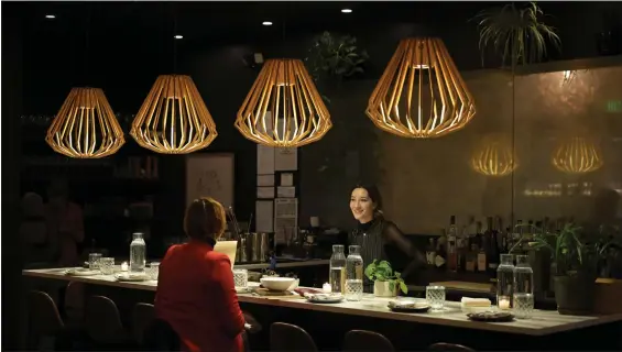  ?? HYOUNG CHANG — THE DENVER POST ?? Bartender Nella Milie, right, serves customers at Annette in Stanley Marketplac­e in Aurora on Nov. 28, 2023.