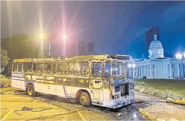  ?? AFP ?? The charred remains of a bus are seen near Sri Lanka’s outgoing prime minister Mahinda Rajapaksa’s official residence in Colombo on Monday.