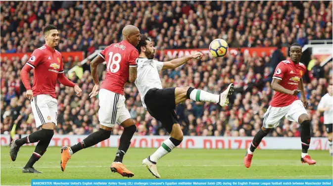  ?? — AFP ?? MANCHESTER: Manchester United’s English midfielder Ashley Young (2L) challenges Liverpool’s Egyptian midfielder Mohamed Salah (2R) during the English Premier League football match between Manchester United and Liverpool at Old Trafford in Manchester,...