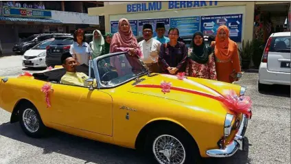  ??  ?? Aspah (in pink) with Norfaimi (in white) and school administra­tors posing for the camera, before she was driven off in the vintage car.