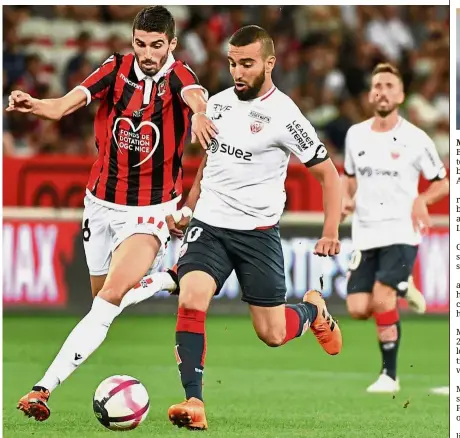  ??  ?? Hard at work: Dijon midfielder Naim Sliti (right) vying for the ball with Nice midfielder Pierre Lees-Melou during the French Ligue 1 match last week. — AFP